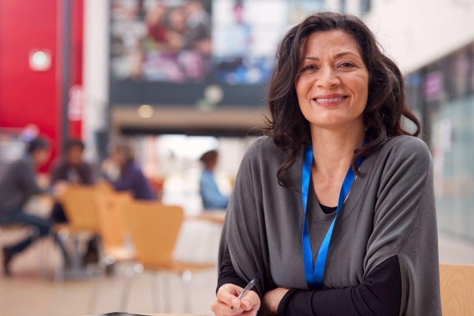 A mature woman sitting in a lounge area smiling