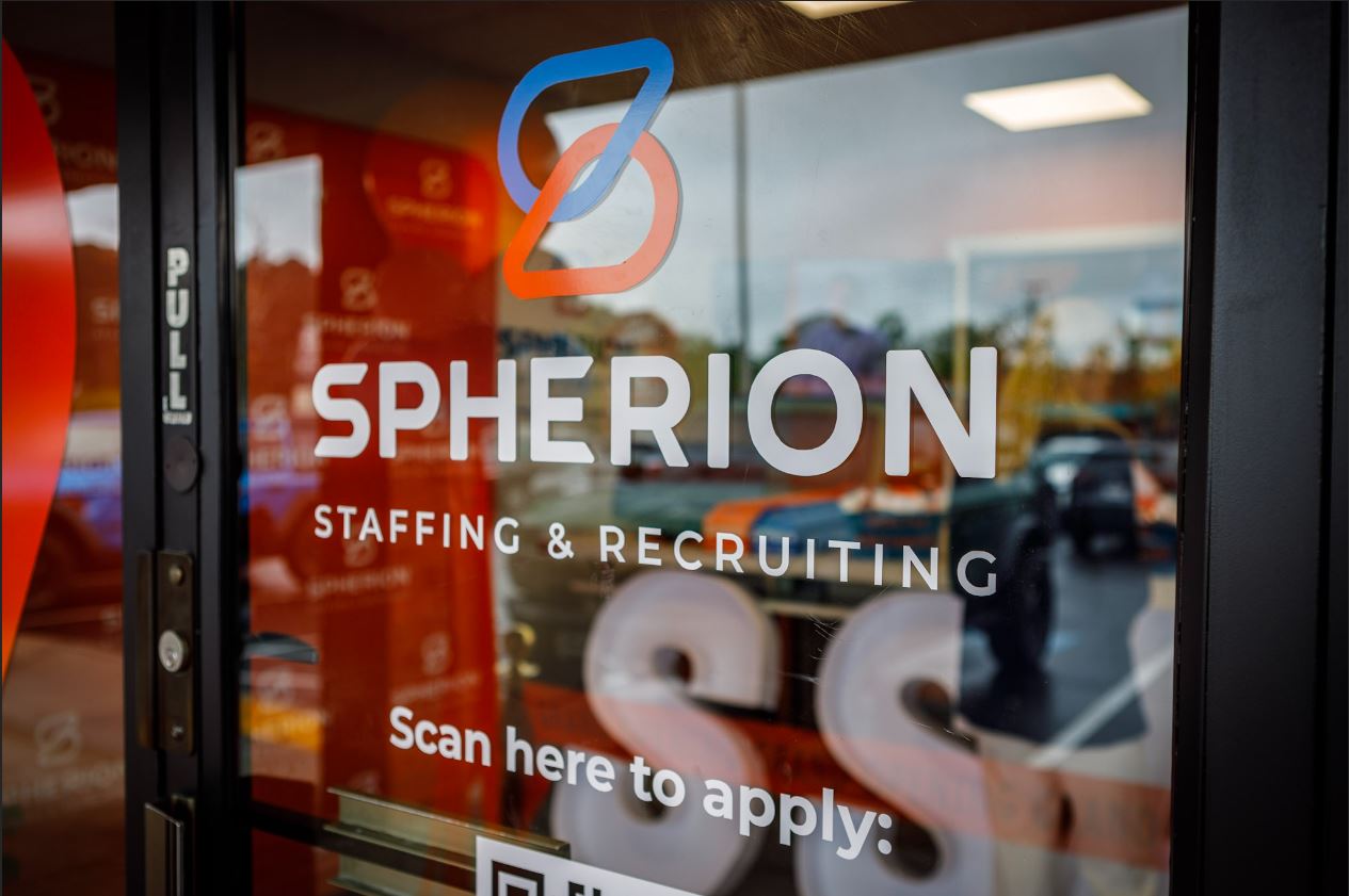 Close-up photo of a glass door with the Spherion Staffing & Recruiting logo on the door.