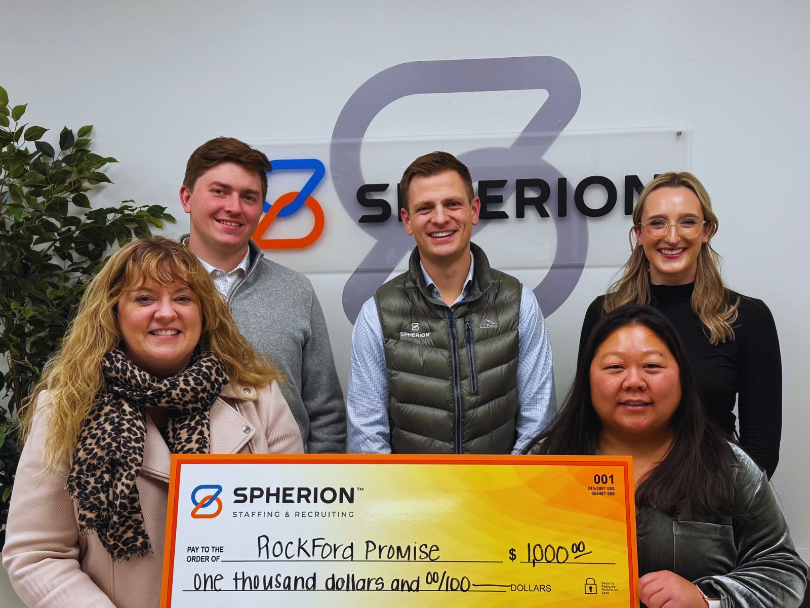 A group of professionals presenting a check to a nonprofit organization