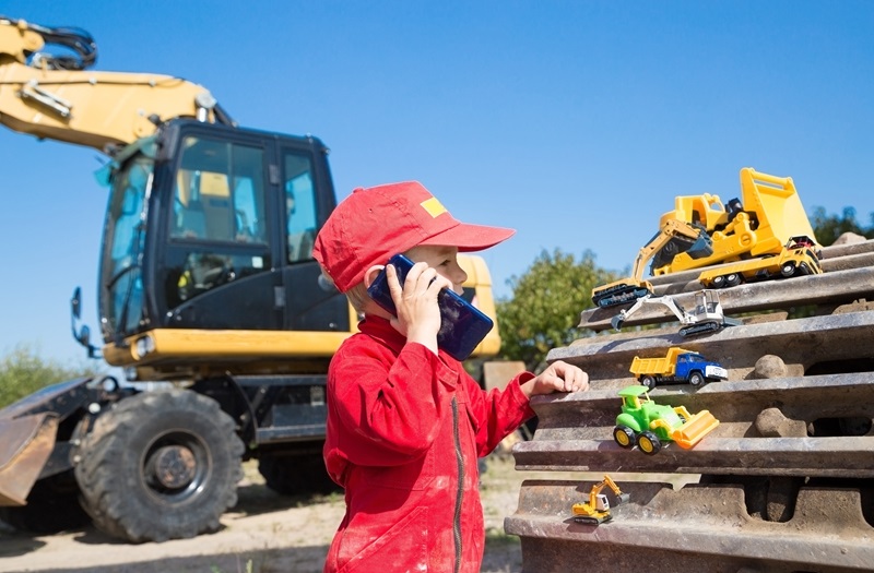 Boy with construction toys on site