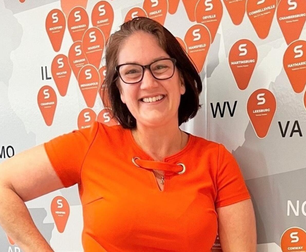 Lindsey Hack with map Lindsey Hack in front of map