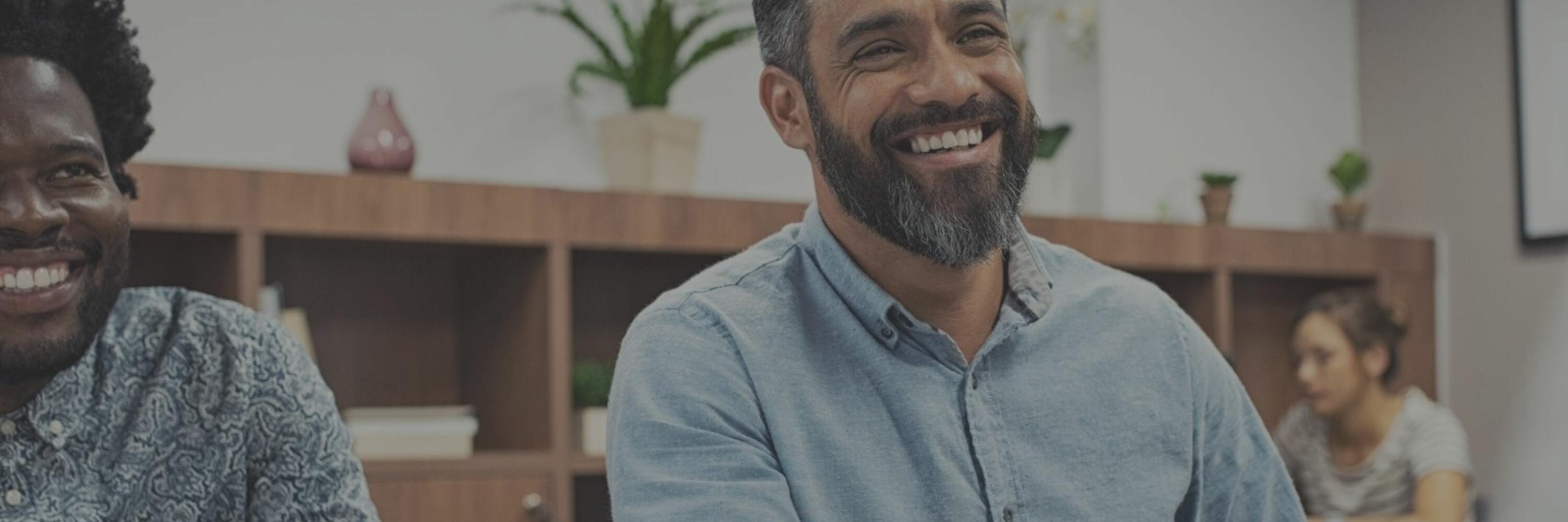 Spherion Staffing helps grow your business A smiling man shaking hands in an office setting