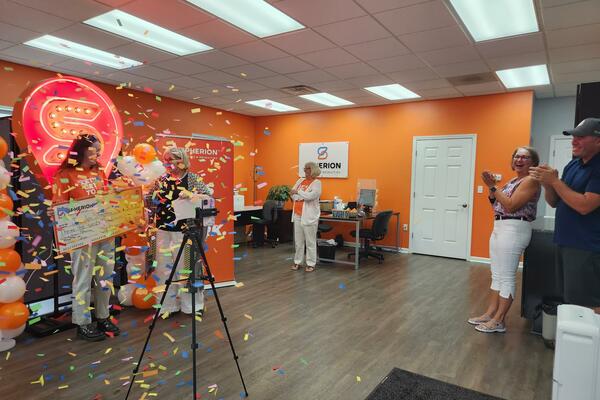 A wide-angle photo of an orange room with people filing and confetti in the air